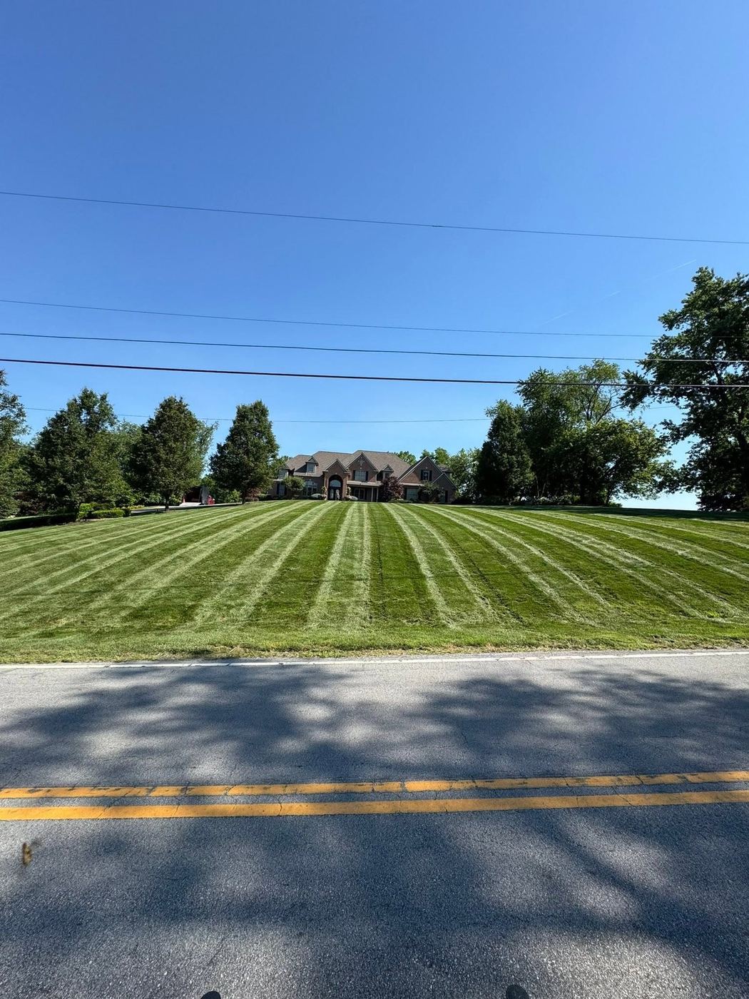 Large striped front lawn viewed from the road on a rural Medina County property