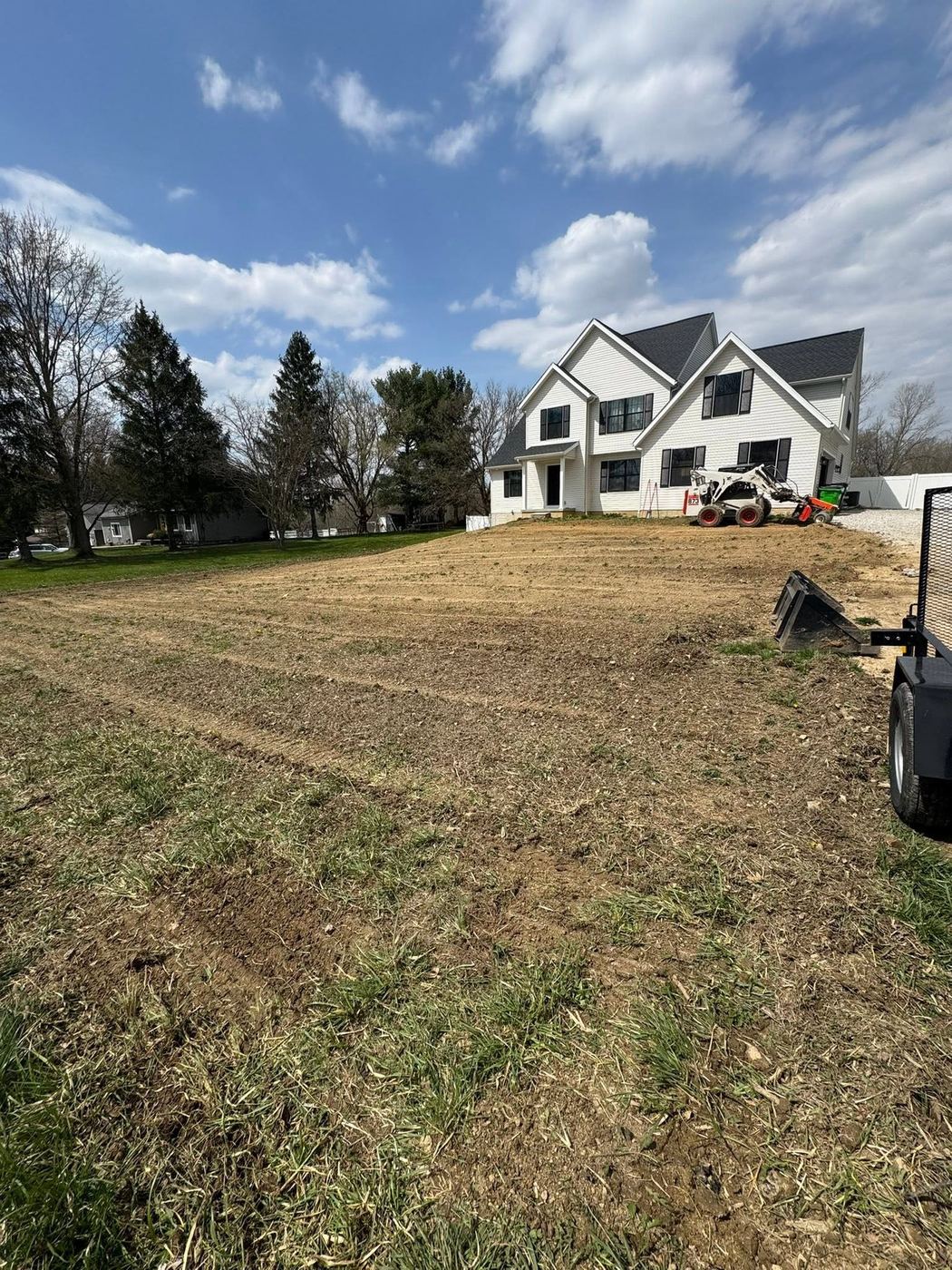 Graded and prepped soil ready for new lawn installation in front of a newly built home